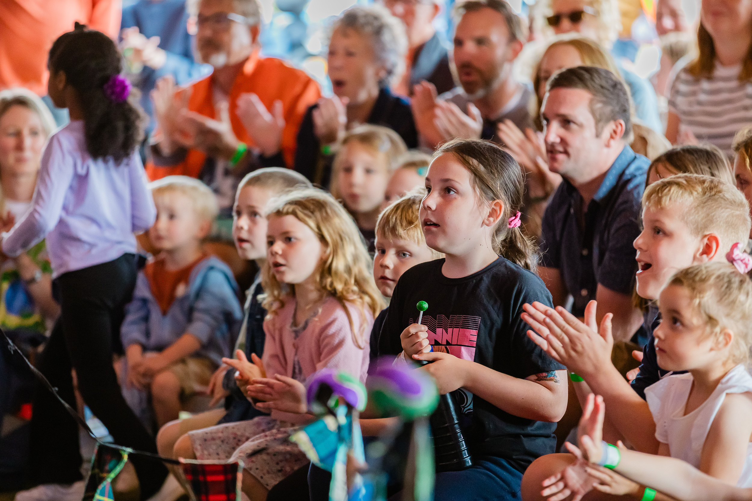 A group watching a performance smiling and clapping