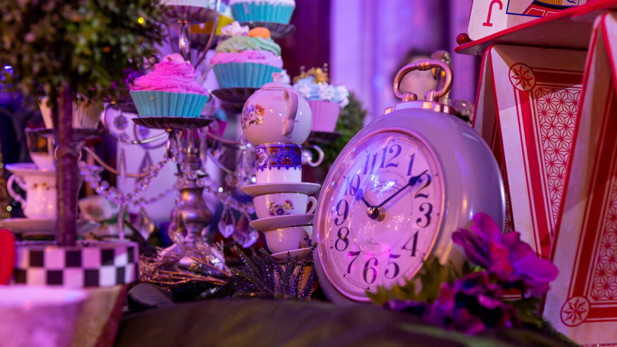 Cakes, playing cards and a clock in an alice in wonderland display